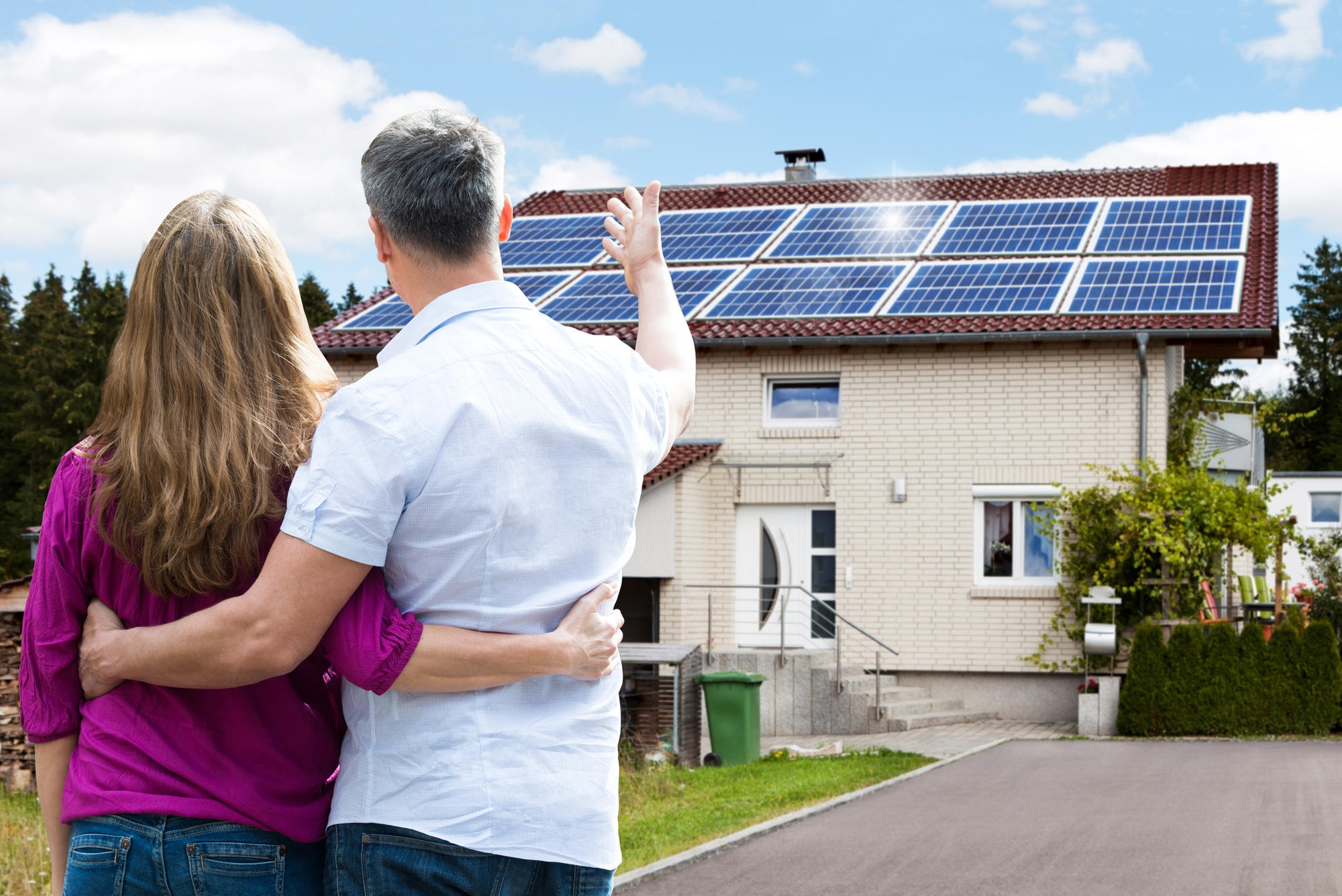 Rear View Of Couple Standing In Front Of Their House